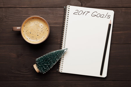 Cup of coffee and notebook with goals for 2017. Planning and motivation for the new year concept....