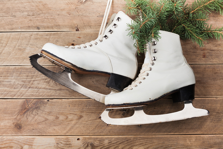Vintage ice skates for figure skating with fir tree branch hanging on rustic background. Christmas decoration.の写真素材