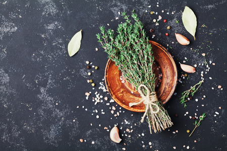 Food background of herb thyme and spices on black kitchen table top view.の写真素材