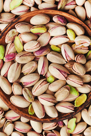 Bowl of pistachio nuts on wooden table from above. Healthy food and snack. の写真素材