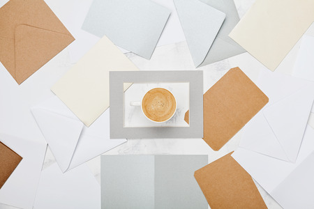 Cup of coffee with mail envelopes pattern top view. Lifestyle correspondence concept background. Flat lay style.の写真素材