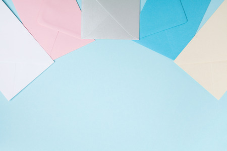 Colorful envelopes on blue table top view. Mockup for business mail, blogging and office correspondence. Flat lay style. の写真素材