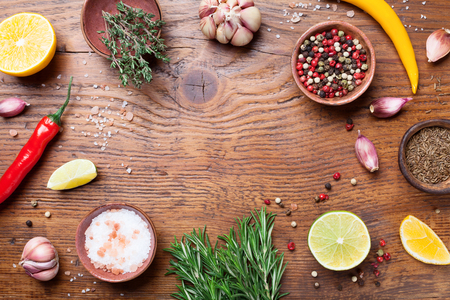 Mixed spices and fresh rosemary on wooden kitchen table top view. Ingredients for cooking. Food background.の写真素材