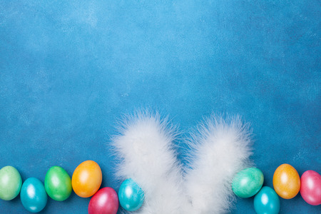 Funny Easter background with colorful Easter eggs and bunny ears top view. Copy space for text.の写真素材