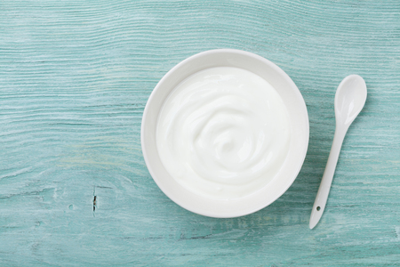 Fresh greek yogurt in bowl on rustic wooden table top view.の写真素材