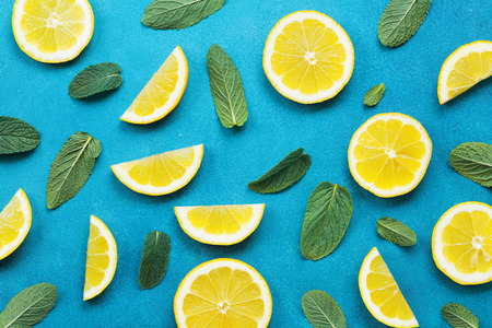 Punchy pastel background with lemon slices and mint leaves. Summer colorful pattern. Flat lay style.の写真素材
