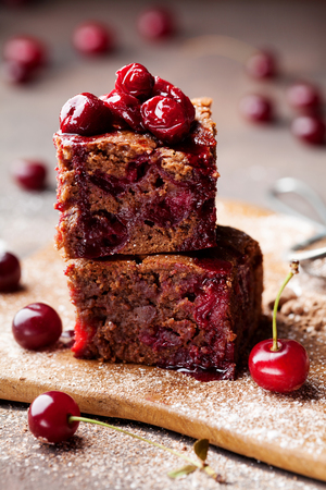 Chocolate brownie cake, dessert with cherry on wooden table.の写真素材