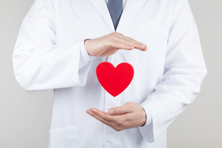 Doctor cardiologist hands with flying heart. Cardiology and heart disease concept.の写真素材