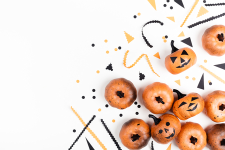 Pumpkin heads and confetti for Halloween party decor on white background top view. Flat lay style.の写真素材