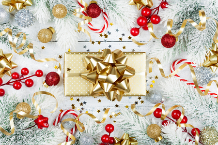 Golden gift or present box, snowy fir tree and christmas decorations on white table top view. Flat lay style.の写真素材