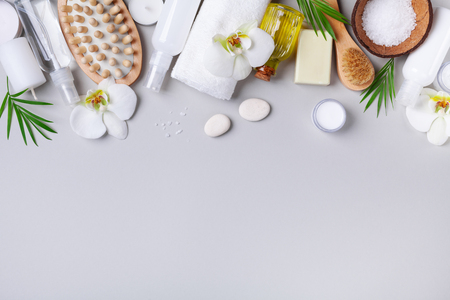 Spa, aromatherapy, beauty treatment and wellness background with massage brush, towel, orchid flowers and cosmetic products. Top view and flat lay.の写真素材