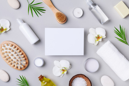 Spa, aromatherapy, beauty treatment and wellness background with massage brush, towel, orchid flowers and cosmetic products. Top view and flat lay. Empty card for text.の写真素材