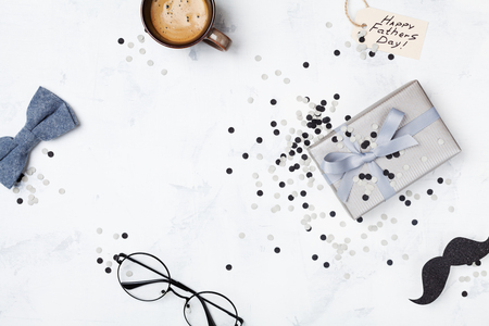 Holiday breakfast on Happy Fathers Day with cup of coffee, gift box, glasses, bowtie and moustache top view. Flat lay.の写真素材