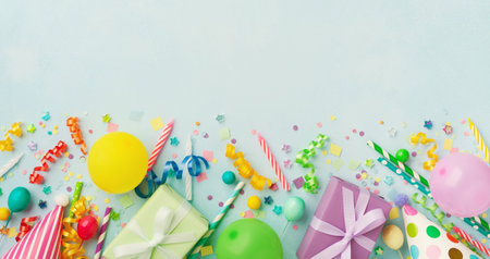 Holiday background with balloons, gift boxes and confetti. Birthday and party supplies on blue table...