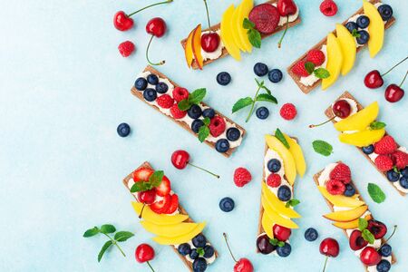 Snack or dessert from sandwiches with creamy cheese and berry fruits top view. Easy summer food for breakfast or lunch.の写真素材