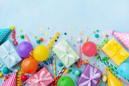 Birthday party table with balloons, gift or present boxes, confetti and holiday supplies. Top view.の写真素材