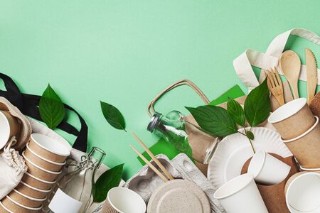Cotton bag, glass jar, green leaves and recycled tableware top view. Zero waste, eco friendly, plastic free background. Flat lay.の写真素材