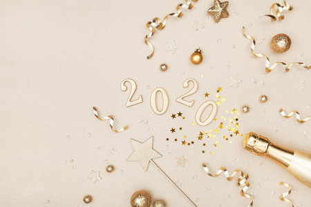 Celebration Christmas and New Year background with golden champagne bottle, holiday decoration, confetti stars and 2020 numbers. Flat lay style.の写真素材