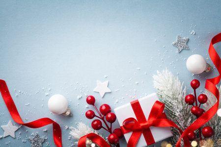 Christmas card. Fir tree branches, holiday decorations and gift or present box on blue background. Top view with space for text.の写真素材