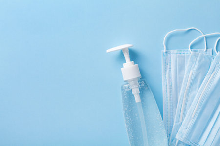 Sanitizer gel or antibacterial soap and face mask for coronavirus preventive measure, top view