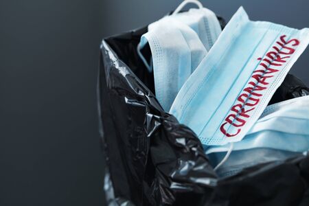 Used medical masks against coronavirus in trash bin. Corona virus or covid-19 concept.の写真素材
