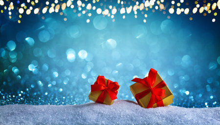 Gift or present box in snow against blue bokeh background. Christmas or New Year composition.の写真素材