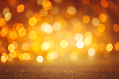Defocused golden Christmas bokeh background. Sparkle abstract shiny festive texture.の写真素材
