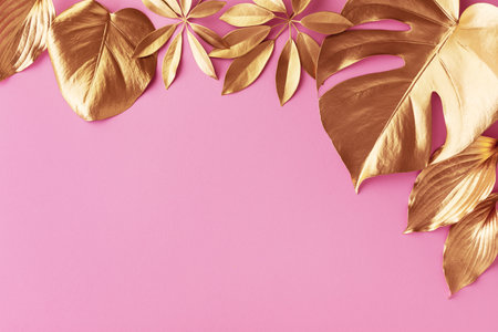 Golden leaf decoration design background. Vintage gold, luxury and trendy natural beauty minimal concept on pink top view and flat lay.の写真素材