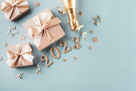Golden gift or present boxes, 2023 numbers and Christmas decorations on blue turquoise background top view. Flat lay composition for New Year.の写真素材