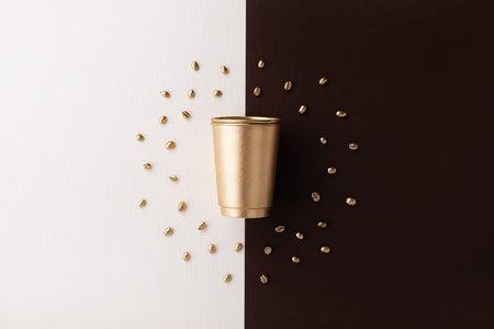 Paper cup of coffee with golden coffee beans top view.の写真素材