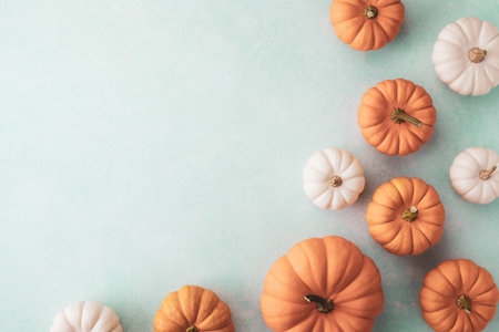 Little decorative pumpkins on blue table top view. Autumn, Thanksgiving or Halloween minimalist greeting cardの写真素材