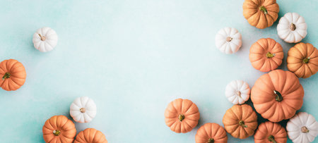 Small decorative pumpkins on turquoise background top view, flat lay. Autumn, Thanksgiving or...