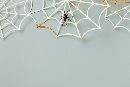 Halloween turquoise minimal background with spider web party decoration top view. Happy halloween holiday greeting card template.の写真素材