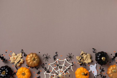 Halloween holiday background with party decorations from pumpkins, bats, spider web and ghosts top view. Happy halloween greeting card flat lay style.の写真素材
