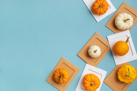 Small decorative pumpkins on turquoise background top view, flat lay. Autumn, Thanksgiving or Halloween backgroundの写真素材