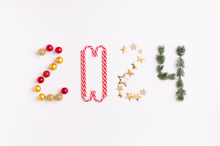 2024 creative christmas and New Year numbers from fir tree and holiday decorations top view. Flat lay style.の写真素材