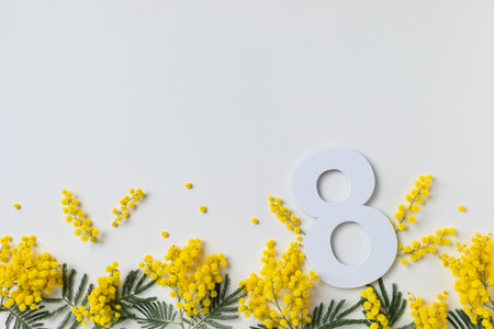 International Women Day on 8 March celebration with fresh spring mimosa flowers and number eight top view. Beautiful holiday greeting background with copy space.の写真素材