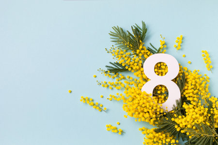 8 March celebration with number eight decorated with spring mimosa flowers top view. Happy Women Day festive background.の写真素材