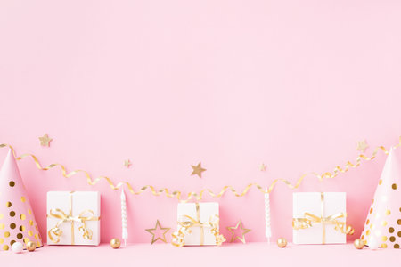 Birthday or party background with carnival cap, gift box and confetti. Festive greeting card.の写真素材