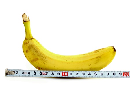 Large banana and measuring tape on white backgroundの写真素材