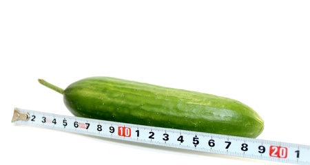 Large cucumber and a measuring tape on white backgroundの写真素材