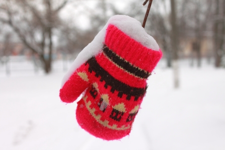 Red mitten in the snow in winterの写真素材