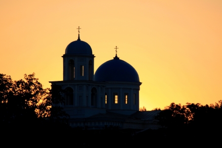 Silhouette of churches on a golden sky and the sunの写真素材