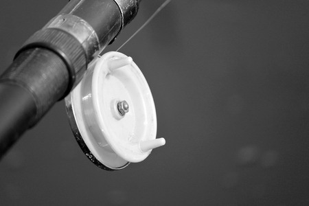 Fishing rod with a reel close-up, black and white photoの写真素材