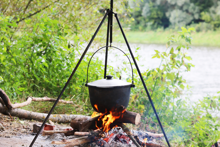Cooking food in summer on nature at stake in cauldronの写真素材