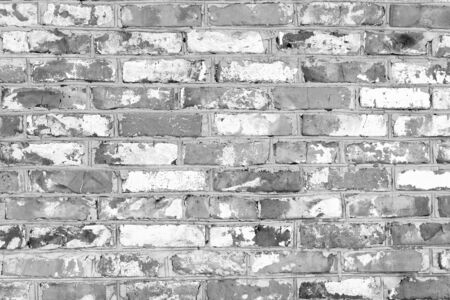 Black and white photo with image of brick wall made of old bricks with different texturesの写真素材