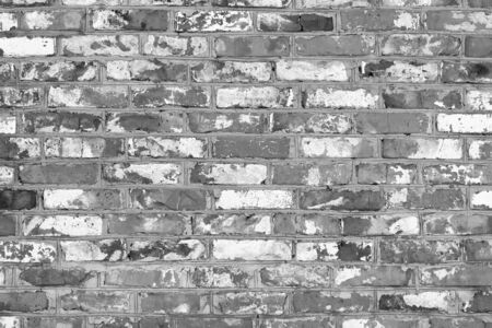 Black and white photo with image of brick wall made of old bricks with different texturesの写真素材