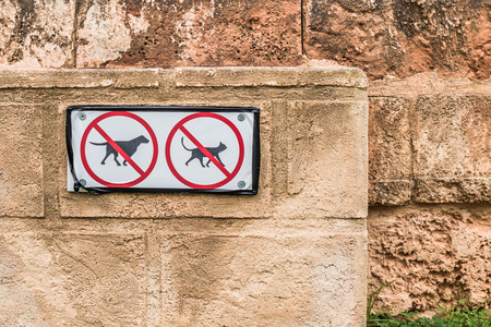 Conceptual No Dog and Cat Pets Allowed Signs on Old Textured Brown Wallの写真素材