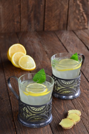 Hot ginger and lemon drink on wooden backgroundの写真素材