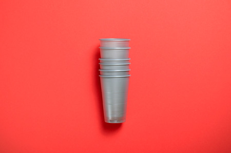 Grey Plastic Cups on Bright Orange Background, Single Use Plastic Cups, Food Conceptの写真素材